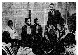 Rev. Milton Galamison in a "600" school classroom with a group of black teenagers
