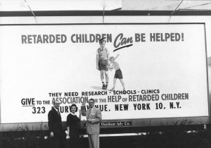 Parent activists in front of a billboard that reads, "Retarded Children Can be Helped! They need Research, Schools, Clinics. Give to AHRC"