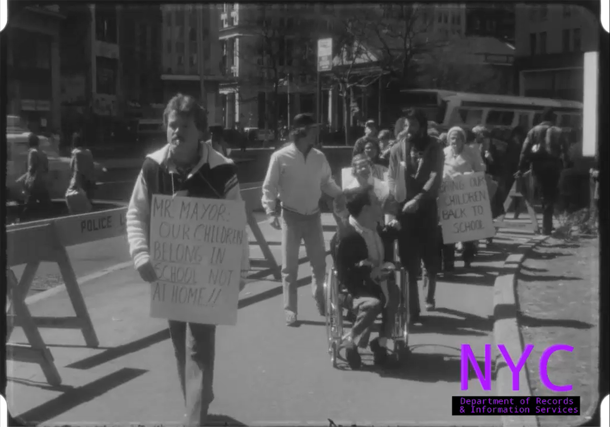 Children with disabilities, some in wheelchairs, march with their parents near City Hall in Manhattan